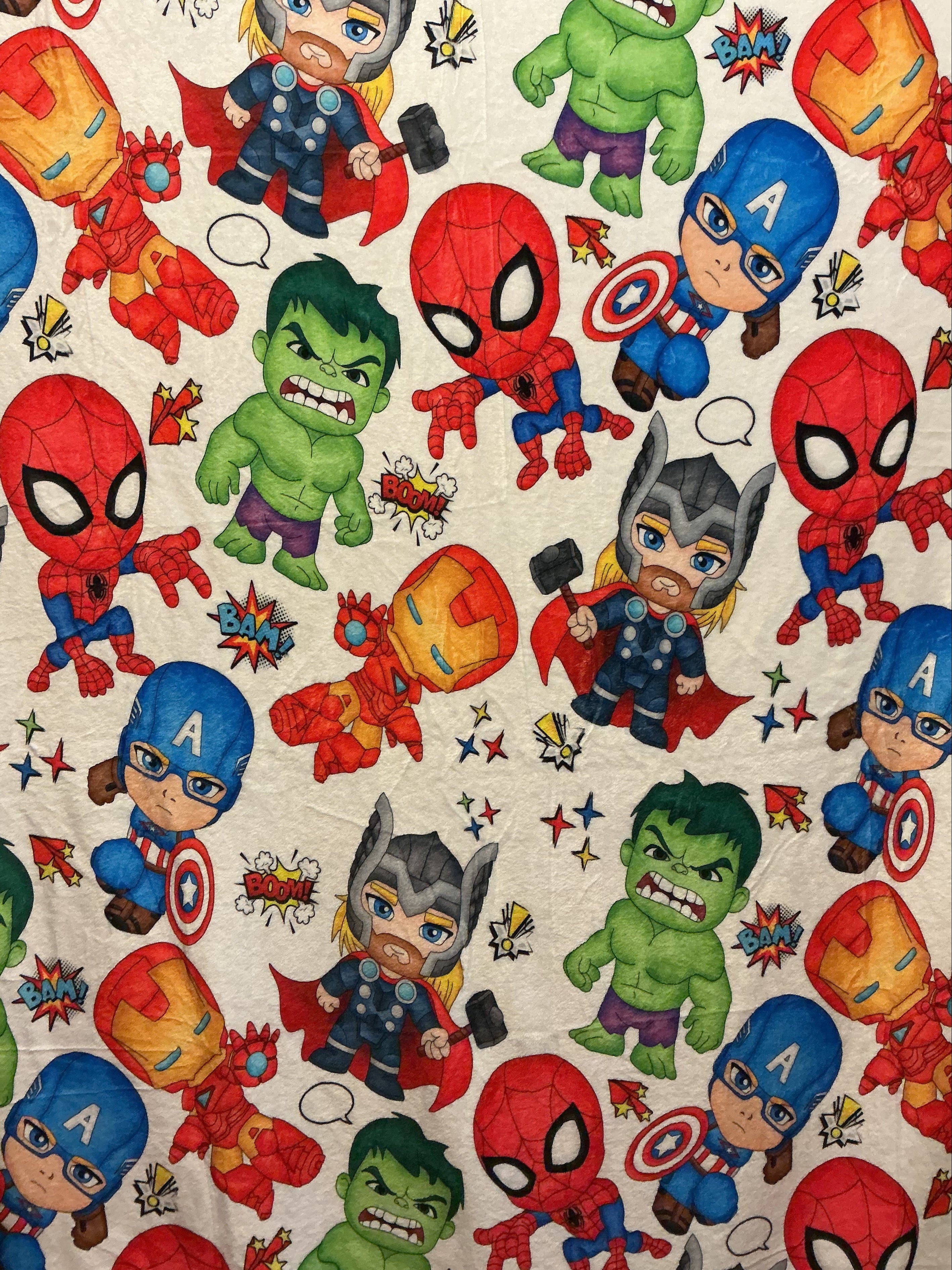 Plush blanket with colorful cartoon Avengers characters, including Spider-Man, Captain America, Thor, Hulk, and Iron Man on a light background.