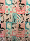 A patchwork print featuring a duck-themed design with illustrations of mallards, floral motifs, and the word 'Carhartt' printed on pink and teal sections.